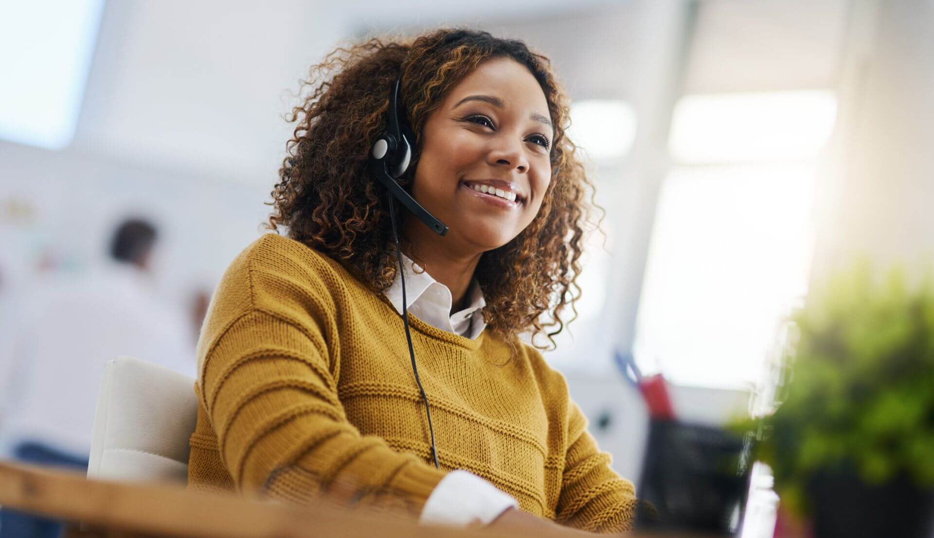 A Woman in an Office Wearing a Headset, Using a VoIP Solution for Communication