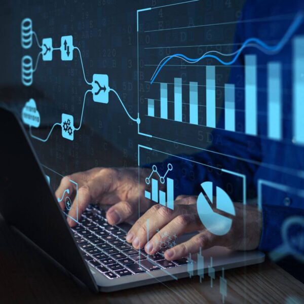 A Focused Analyst Typing on a Laptop, With Graphs and Charts Displayed on the Screen, Analyzing Data