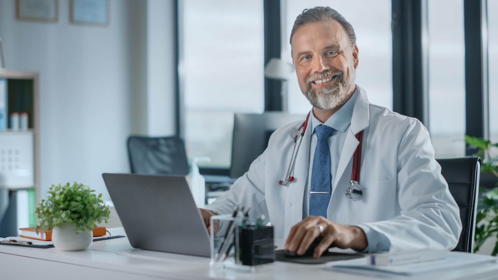 Portrait of a Cheerful Doctor With a Warm Smile, Wearing a White Lab Coat and Stethoscope