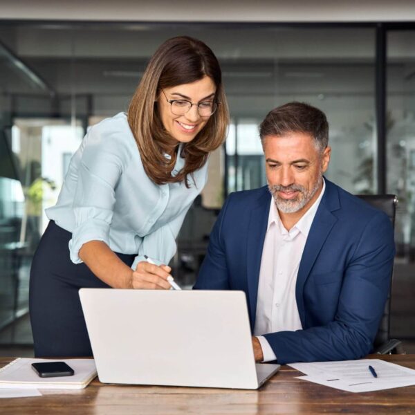 Two Coworkers Discussing While Working on a Laptop Together